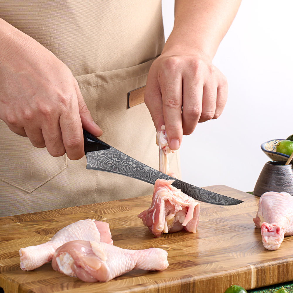 Person cutting chicken on a wooden cutting board with a knife