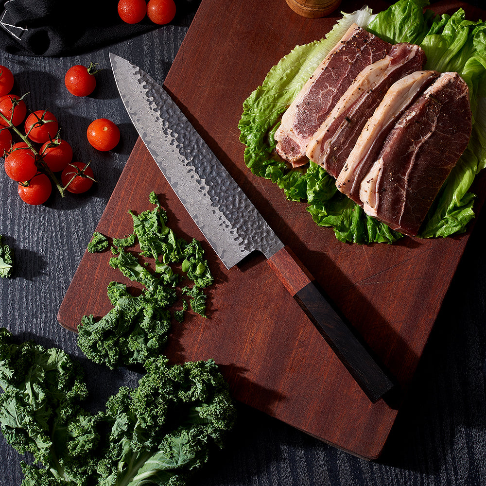 Japanese Chef knife with damascus and bamboo near steaks