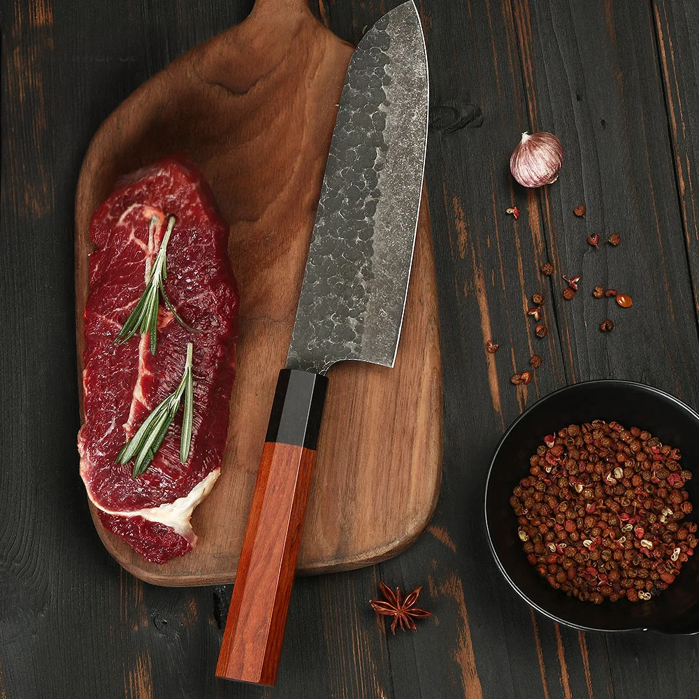 Professional japanese carbon steel santoku knife on a wooden board near a steak