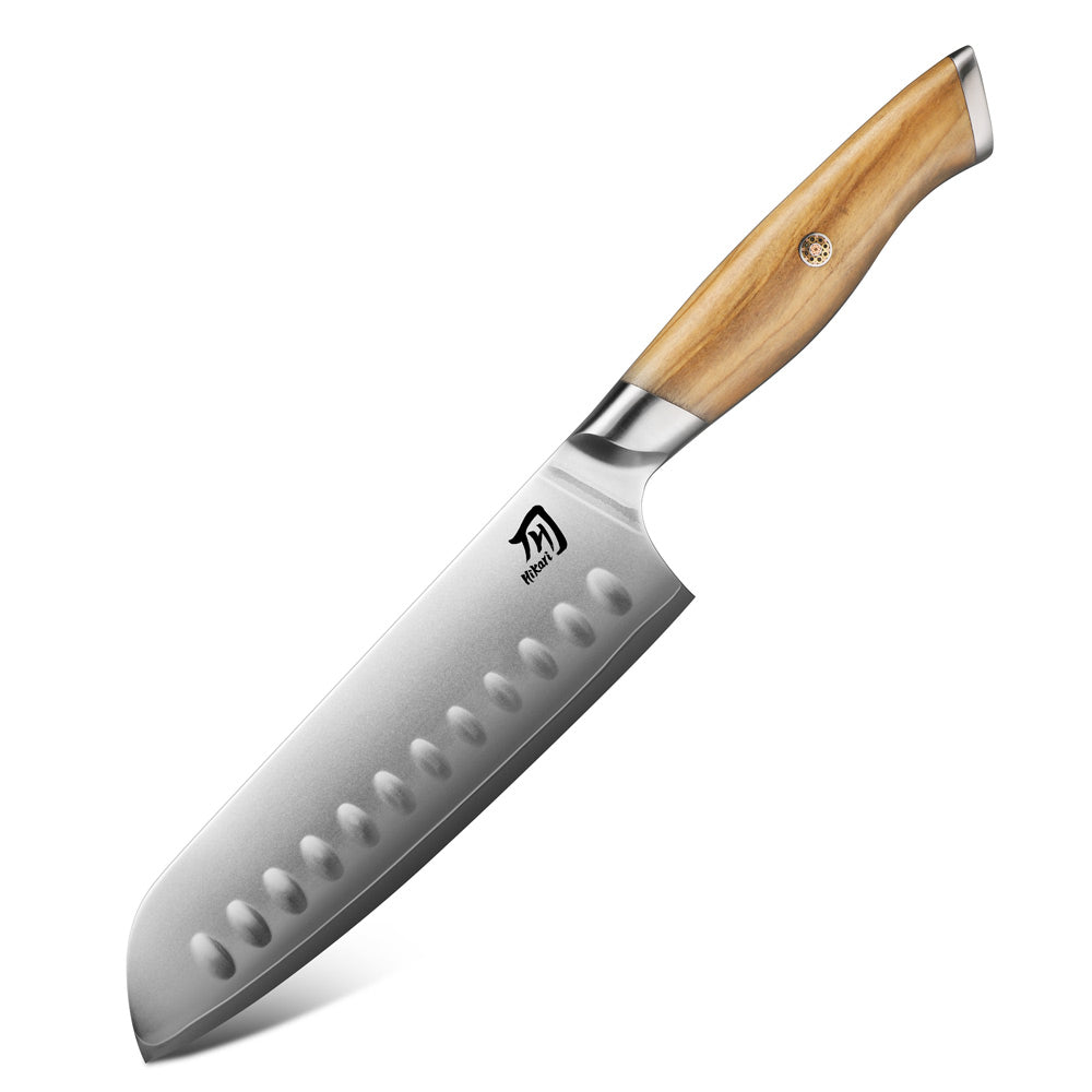 A Santoku knife with a silver steel blade featuring a serrated edge and dimpled cutting pattern, and a light brown wooden handle with a silver bolster, shown on a white background.